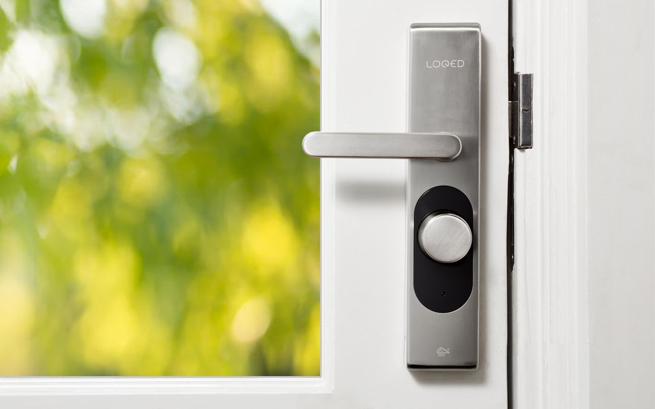 Serrure connectée installée sur une porte blanche